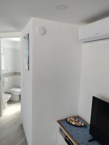 a bathroom with a television and a table with food on it at Attichetto monolocale vista mare terrazzatissimo Asterspace in Anzio +54 photos