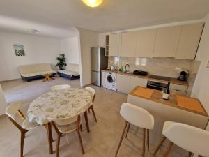 a kitchen and living room with a table and chairs at Apartments Adriatic in Korčula