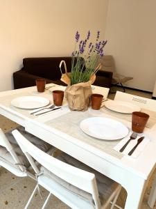 a white table with plates and purple flowers on it at Cà di Scirocco in Varigotti