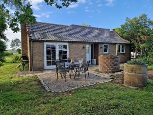 een tafel en stoelen voor een klein huis bij Het Karnhuis in Schoondijke