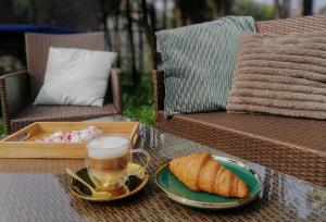 a cup of coffee and a plate of bread on a table at Sky&Lake Apartments Gdańsk in Gdańsk