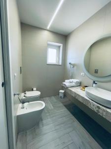 a bathroom with two sinks and a large mirror at Aquamarì Charme Rooms in Vieste +37 photos