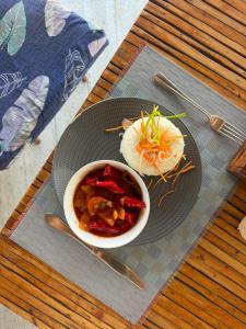 a plate with a bowl of food on a table at Highland Bungalows in Nungwi