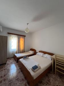 a bedroom with two beds and a window at Niks Apartments in Ksamil