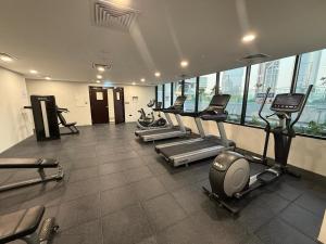 a gym with treadmills and ellipticals in a building at 1 Bed Junior near Cleveland and Galleria Mall by Central Stay in Abu Dhabi