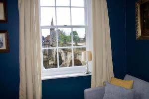 a window in a blue room with a view of a city at English Bridge Court in Shrewsbury