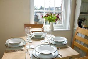 a table with plates and glasses and a vase with flowers at English Bridge Court in Shrewsbury