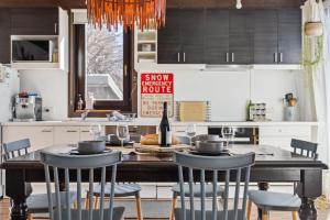 a kitchen with a table with chairs and a bottle of wine at Oliver Haus 4 Bedroom in Berridale +15 photos