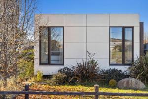 a white house with windows and a fence at Oliver Haus 4 Bedroom in Berridale