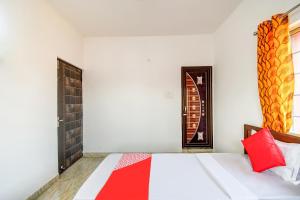 贾姆谢德布尔Hotel O Creation Premium的一间卧室配有一张红色枕头的床 更多19张照片