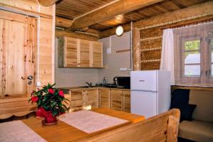 a kitchen with a table and a white refrigerator at Domki na Skalistej w Szczyrku in Szczyrk +14 photos