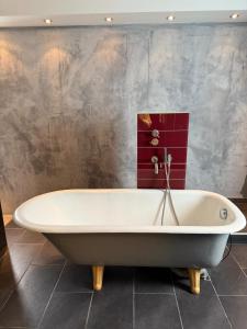 a bath tub in a bathroom with a wall at Apartment 1 in Pulheim