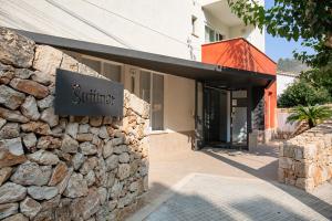 Un edificio de piedra con un cartel en la pared. en Hostal Residencia Sutimar, en Paguera