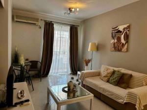 salon z kanapą i stołem w obiekcie Piraeus Lux Secret w Pireusie