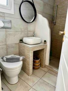 łazienka z umywalką, toaletą i lustrem w obiekcie Piraeus Lux Secret w Pireusie