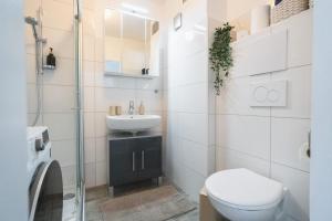ein weißes Badezimmer mit Toilette und Waschbecken in der Unterkunft Gemütliche Ferienwohnung mit Berg und Alpsee Panorama im Allgäu in Immenstadt im Allgäu + 31 Fotos