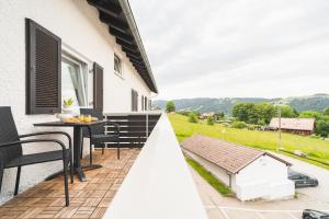 ein Balkon eines Hauses mit einem Tisch und Stühlen in der Unterkunft Gemütliche Ferienwohnung mit Berg und Alpsee Panorama im Allgäu in Immenstadt im Allgäu
