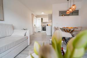 ein Wohnzimmer mit einer weißen Couch und einem Tisch in der Unterkunft Gemütliche Ferienwohnung mit Berg und Alpsee Panorama im Allgäu in Immenstadt im Allgäu