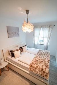 ein großes Bett in einem Zimmer mit einem großen Fenster in der Unterkunft Gemütliche Ferienwohnung mit Berg und Alpsee Panorama im Allgäu in Immenstadt im Allgäu