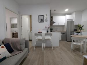 a living room and kitchen with a couch and a table at Alojamiento huerto Altabix in Elche