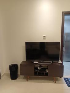 a flat screen tv sitting on a wooden entertainment center at Cozy Beautiful Private Room with Shared Washroom in Ajman 