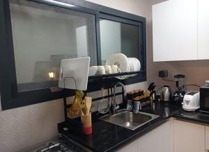 a kitchen counter with a sink and a mirror at Cozy Beautiful Private Room with Shared Washroom in Ajman  +3 photos
