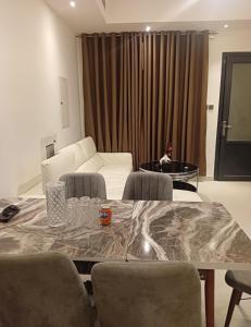 a living room with a table and a white couch at Cozy Beautiful Private Room with Shared Washroom in Ajman 