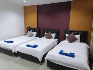 a bedroom with two beds with blue and white sheets at Patong Beach Dream House in Patong Beach