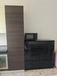 a room with a cabinet with a microwave and a table at Torino Cozy Lodge in Turin