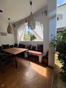 a dining room with a table and chairs and a window at Siri Beach Lodge in Nungwi