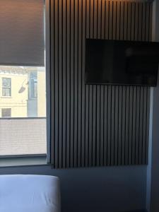 a flat screen tv on a wall next to a window at Carraig Townhouse in Blackrock +33 photos