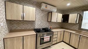 a kitchen with wooden cabinets and a stove at life style apartment in Dhahran