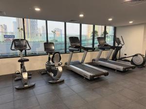 a gym with cardio equipment in a building with windows at Al Maryah Studio near Cleveland and Galleria Mall by Central Stay in Abu Dhabi