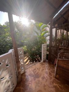a porch with the sun shining through the trees at Siri Beach Lodge in Nungwi