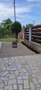 a stone patio with a fence and a tree at Casa de vacanta Musatesti in Robaia