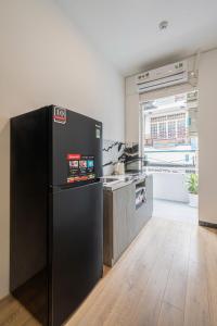 a kitchen with a black refrigerator in a room at Manuka Home in Ho Chi Minh City