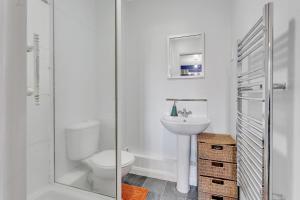 Un baño blanco con inodoro y lavabo. en Wentworth Stay l 3BHK, en Doncaster