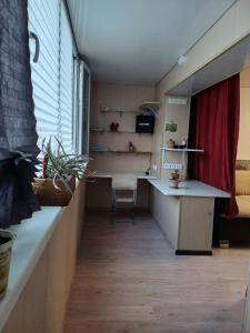 Kleines Zimmer mit einem Schreibtisch und einem roten Vorhang. in der Unterkunft 2х комнатная in Zhezdi