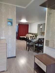 eine Küche und ein Wohnzimmer mit Tisch und Stühlen in der Unterkunft 2х комнатная in Zhezdi