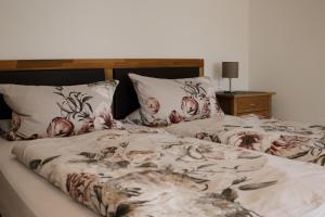 - un lit avec une couverture florale et des oreillers dans l'établissement Idyllisch gelegene Ferienwohnung Xaver im Herzen des bayerischen Waldes, à Zachenberg