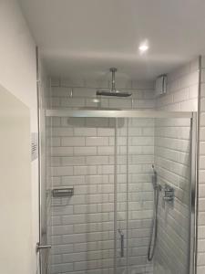 a shower in a bathroom with white tiles at Apartment Nr 15 in Bremerhaven