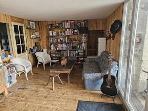 a living room with a guitar and a couch and a table at Ludogîte Graine de Jeux in Espaly-Saint-Marcel