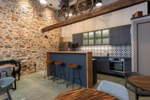 a kitchen with wooden stools and a brick wall at Apartment Studio 7 in Mytilene