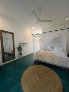 a bedroom with a bed with a mosquito net at Siri Beach Lodge in Nungwi
