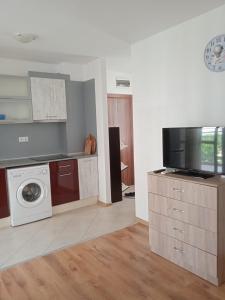 cocina con lavadora y TV en Тристаен апартамент в Бяла комплекс Атлантик, en Byala
