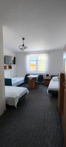 a room with two beds and a table and chairs at Pokoje Jadwiga Konkel in Jastarnia