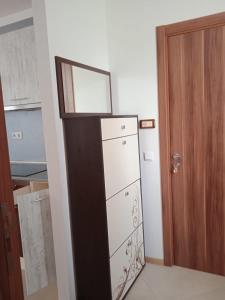 una cocina con nevera junto a una puerta en Тристаен апартамент в Бяла комплекс Атлантик, en Byala 3 fotos más
