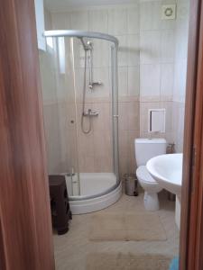 Un baño con ducha, inodoro y lavabo. en Тристаен апартамент в Бяла комплекс Атлантик, en Byala