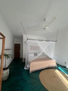 a bedroom with a bed with a mosquito net at Siri Beach Lodge in Nungwi