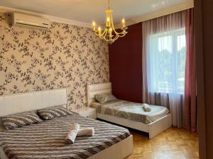 a bedroom with two beds and a chandelier at Green Cape Guest House in Makhinjauri +70 photos